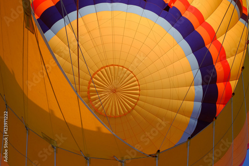 Inside of a colorful hot air balloon as it is inflated for flight.