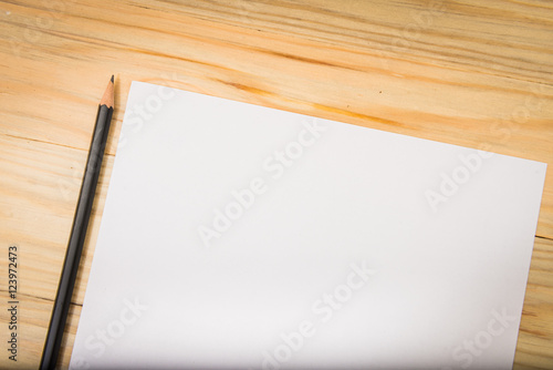 Blank paper with pencil on wood table