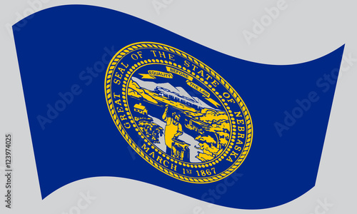 Flag of Nebraska waving on gray background photo