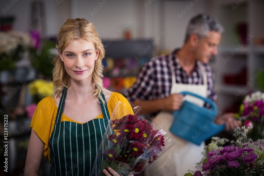 Happy female florist holding flower bouquet
