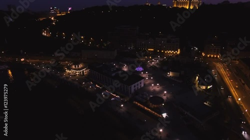 Aerial View of European City at Night with Illuminated Light from Cars, Seafront. Shot in 4K UHD photo