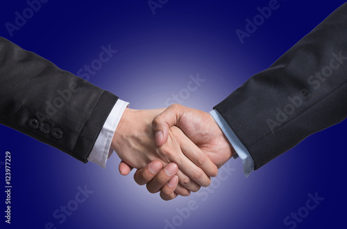 Hand shake between a businessman and a businesswoman on dark blu