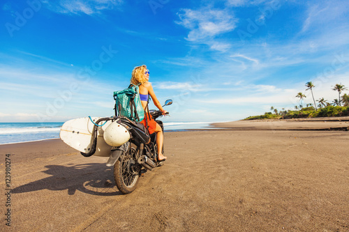 wonderful trip - woman riding a motorcycle with the surfboard
