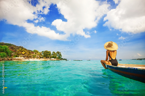back view of a woman sailing a boat in a paradise island
