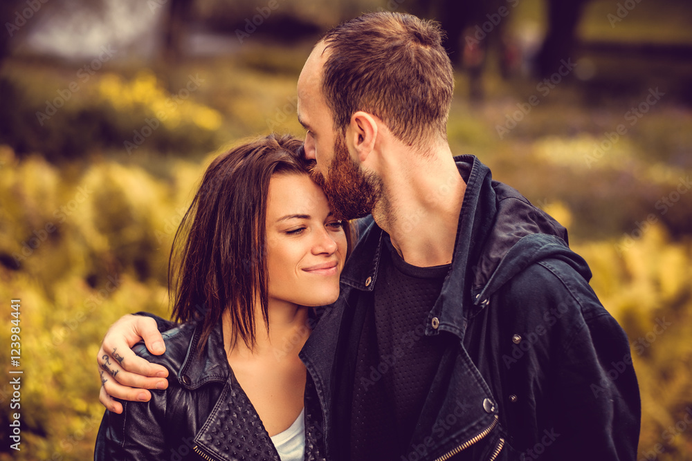 Bearded male kissing cute happy female in a head. Bearded male kissing cute happy female in a head.