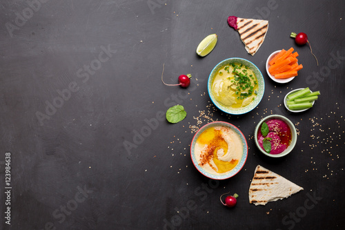 Various vegetarian colorful dips with pita bread photo