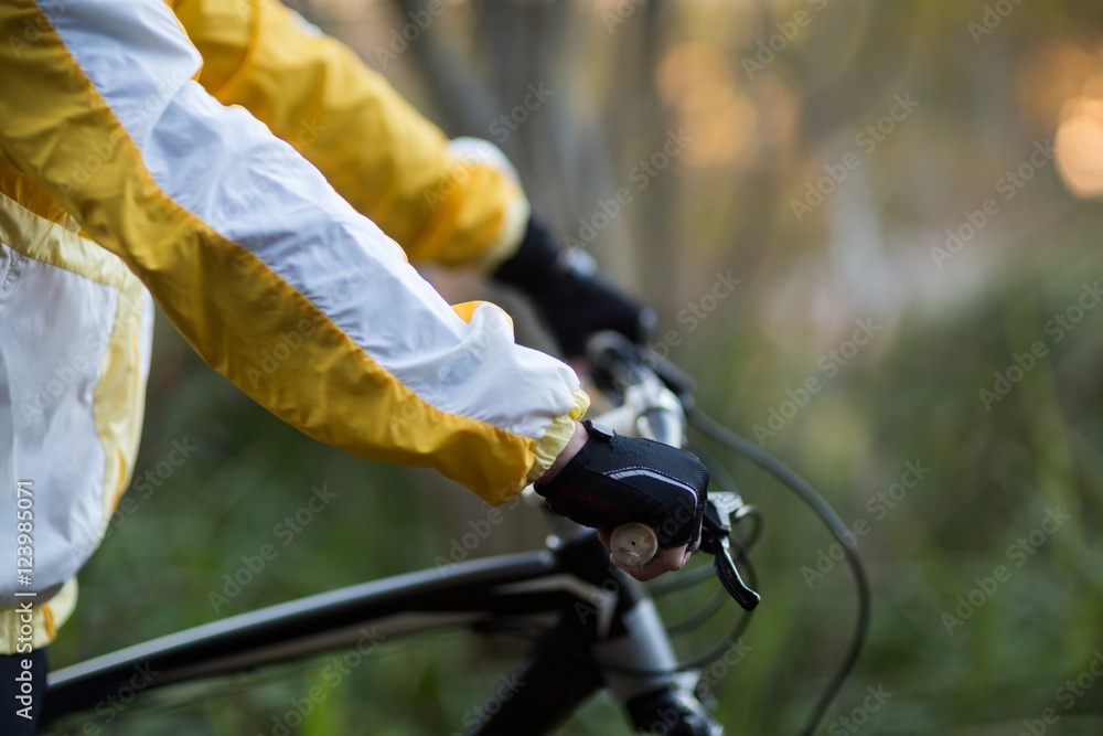 Mid-section of male biker with mountain bike Mid-section of male biker with mountain bike