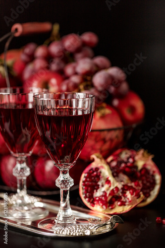 Still life on a dark background. Wine  liquor  glasses  fruits a