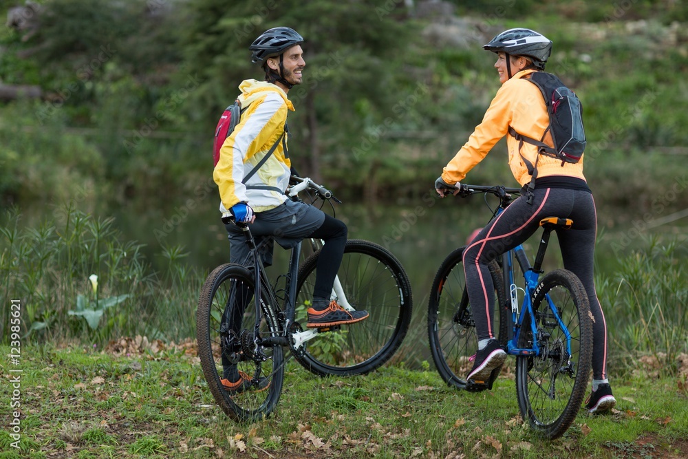 Biker couple interacting with each other with mountain bike