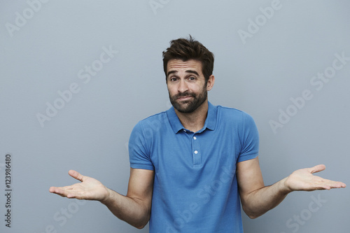 Shrugging man looking at camera