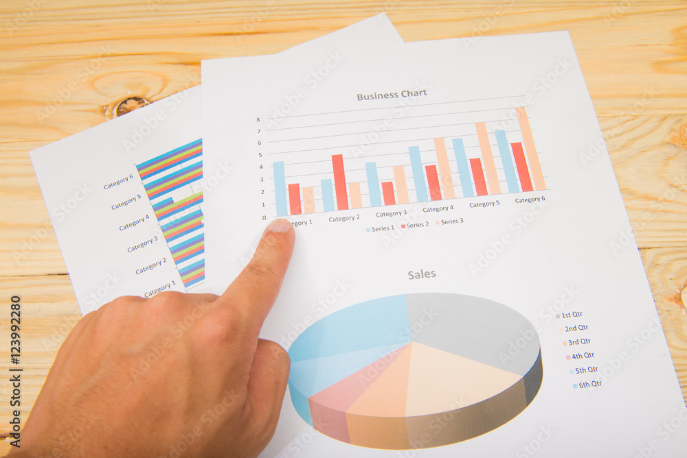 Hand pointing at a colorful chart graph Hand pointing at a colorful chart graph