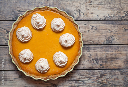 Traditional Homemade Delicious Pumpkin pie with whipped cream and spices made for Thanksgiving, Halloween, top view.