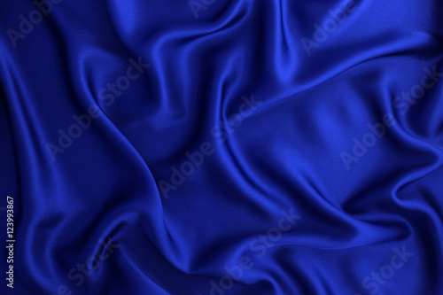 Close up wave luxury blue silk or satin fabric background