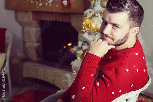 Jeune homme posant devant un cheminée à Noël  photo