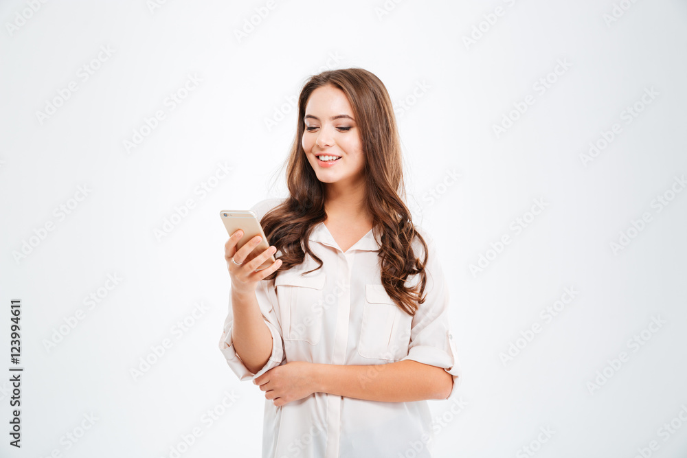 Portrait of a smiling woman holding smartphone over white background Portrait of a smiling woman holding smartphone over white background
