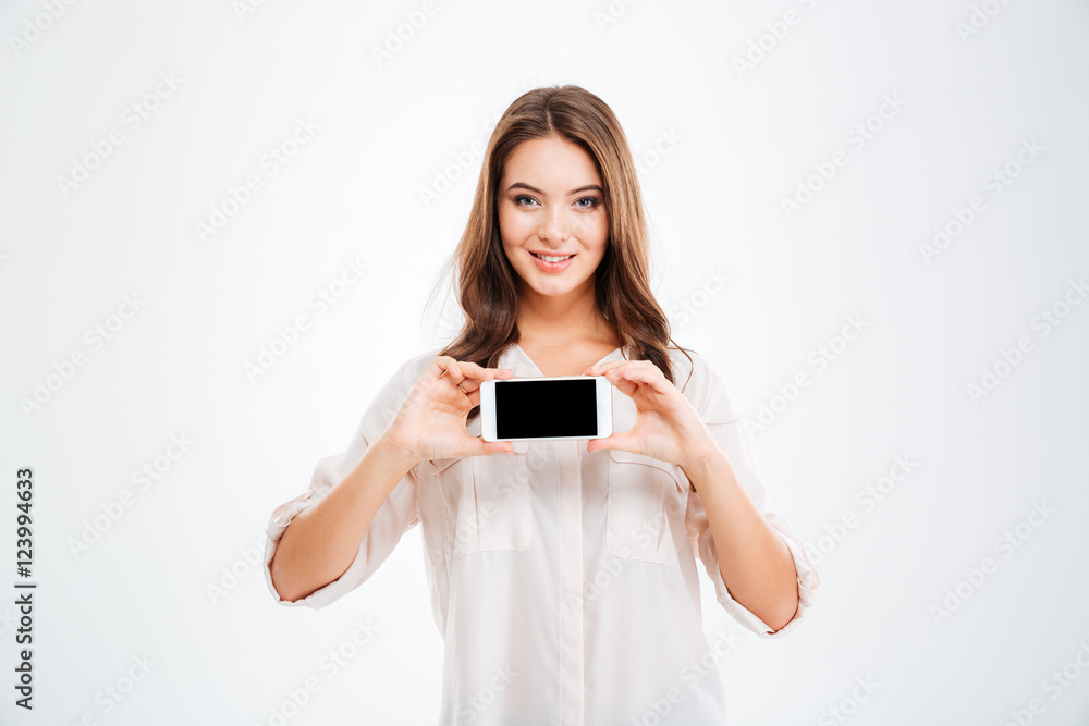 Smiling woman showing blank smartphone screen isolated on white background Smiling woman showing blank smartphone screen isolated on white background