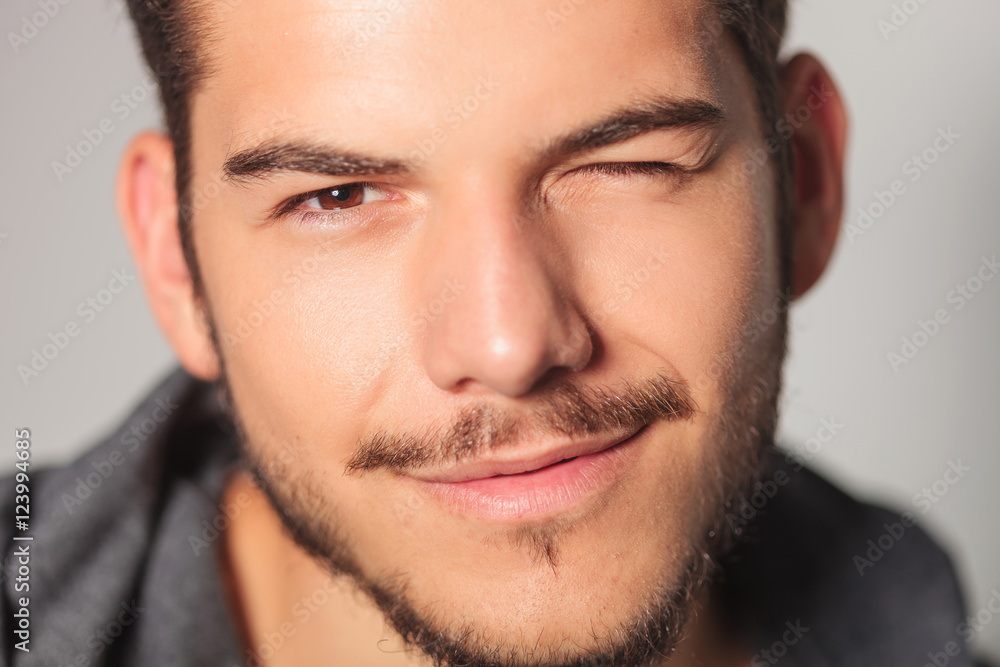 Obraz premium smilling young man is winking his eye