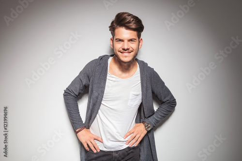 smiling young casual man with hands on waist