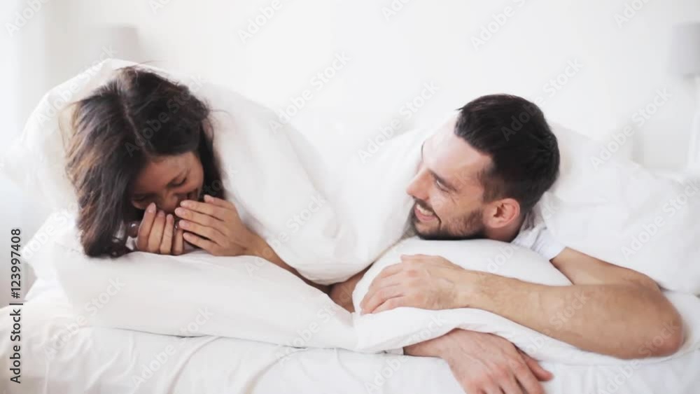 happy couple lying in bed at home happy couple lying in bed at home