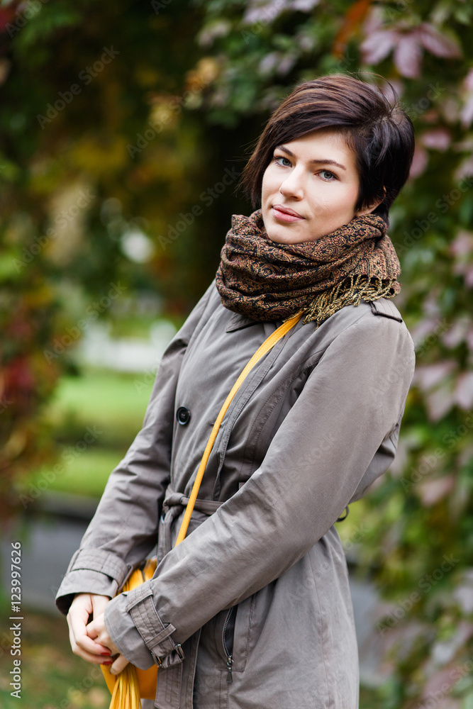 Beautiful brunette woman posing on background of autumn nature Beautiful brunette woman posing on background of autumn nature