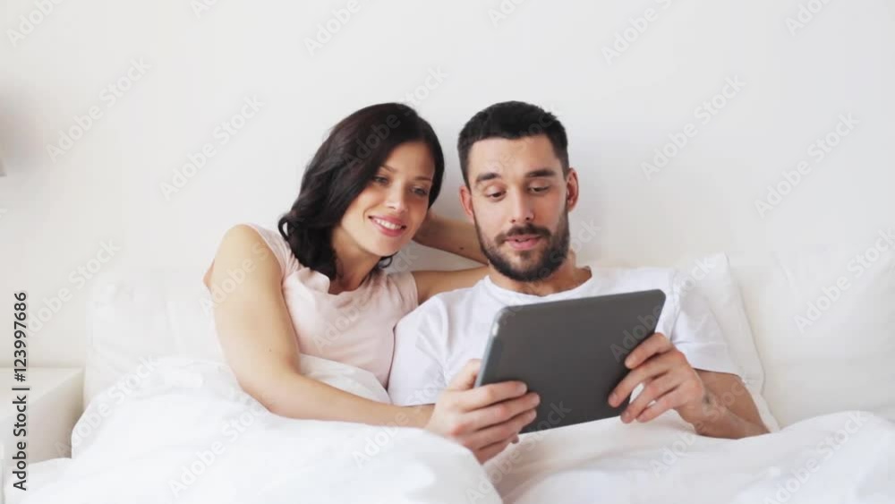 smiling couple in bed with tablet pc computer smiling couple in bed with tablet pc computer
