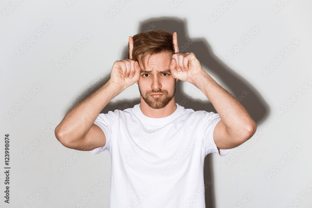 An emotional image of a young caucasian man with a beard in a white t-shirt on a bright background An emotional image of a young caucasian man with a beard in a white t-shirt on a bright background