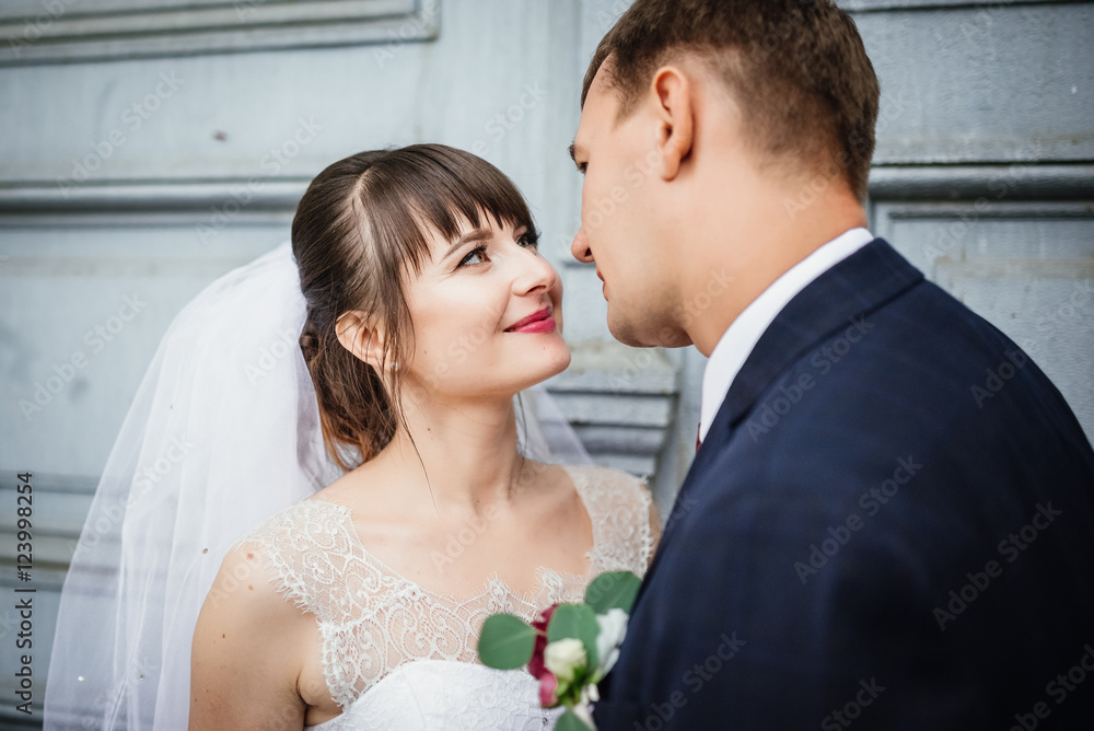 Bride and groom at wedding Day walking Outdoors near architecture. Bridal couple, Newlywed woman and man embracing with love Bride and groom at wedding Day walking Outdoors near architecture. Bridal couple, Newlywed woman and man embracing with love