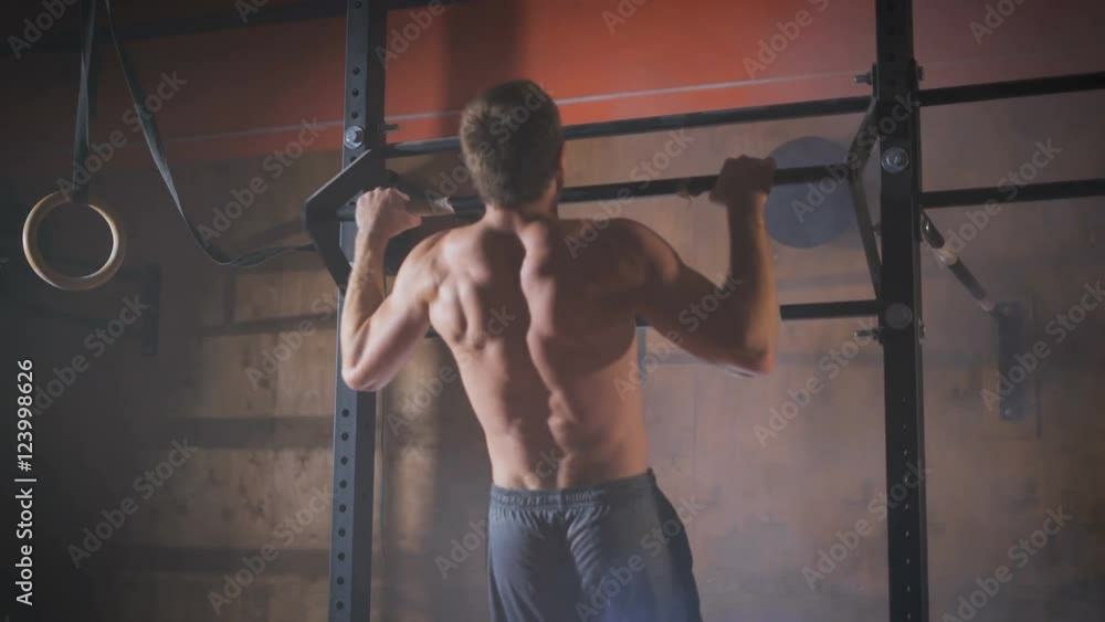 Young muscular athlete doing pull-up exercises. Young muscular athlete doing pull-up exercises.