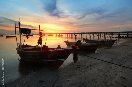 Silhouette natural background of small fishing boats moored beached on the beach during time the sunset and the beautiful natural of the colorful sky at BangPhra beach , Chonburi province in Thailand
