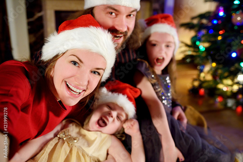 Young happy family of four taking a photo of themselves on Christmas