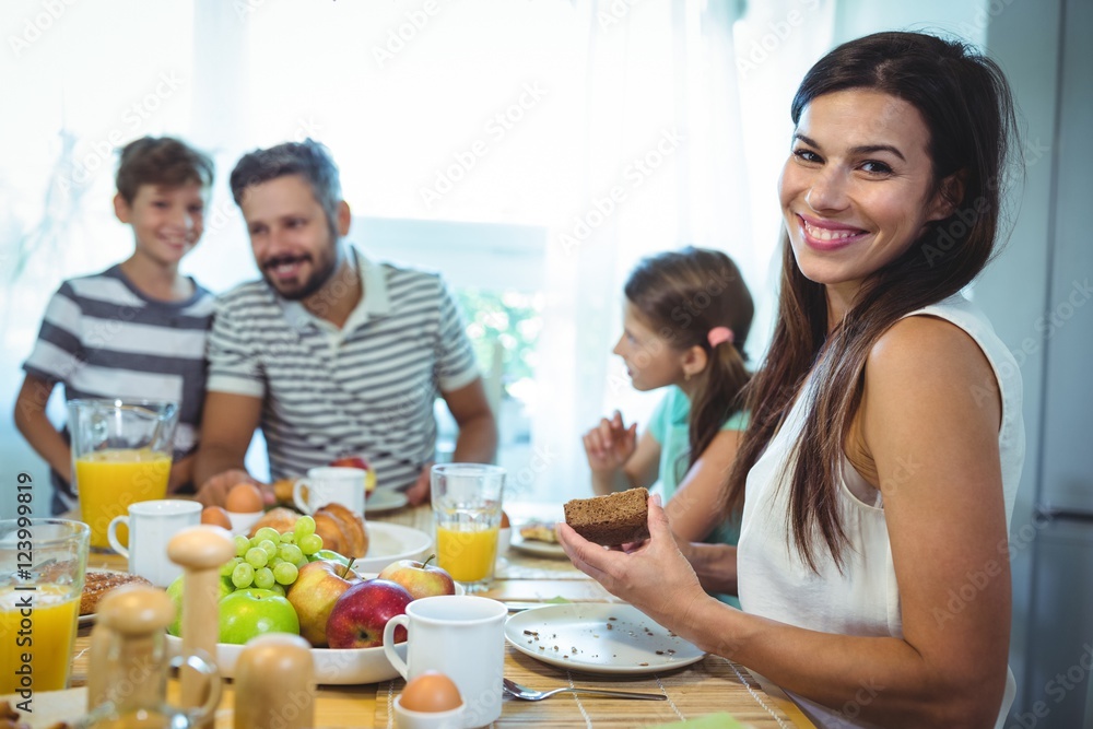 Portrait of happy woman sitting at breakfast table
