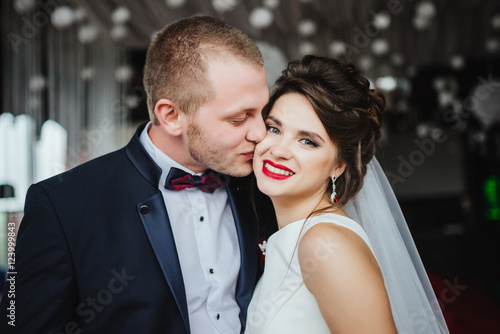 Wedding day. Groom kisses smiling and happy bride after wedding ceremony. Romantic momment