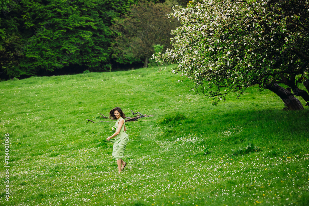 beautiful young woman walking in a green garden beautiful young woman walking in a green garden