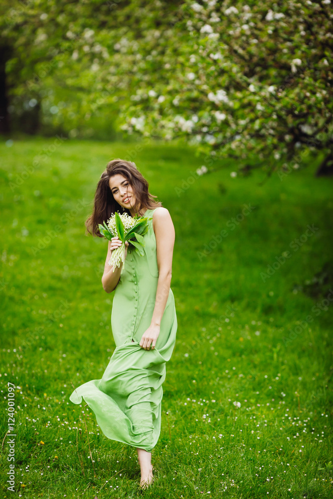 beautiful young woman walking in a green garden beautiful young woman walking in a green garden