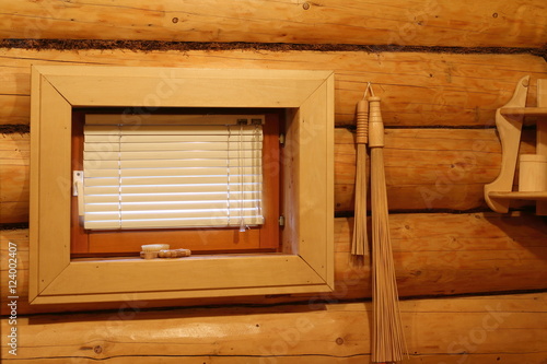 Окно и банные принадлежности на бревенчатой стене в русской бане. photo