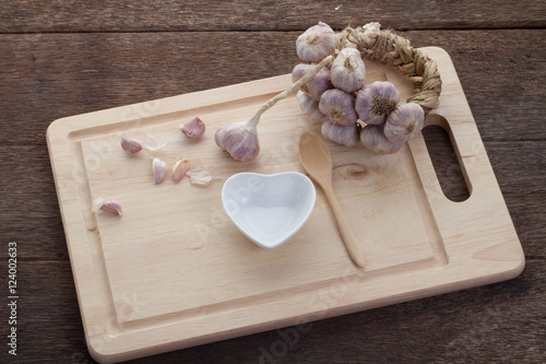 Thailand garlic on a wooden cutting board and Heart-shaped porce photo