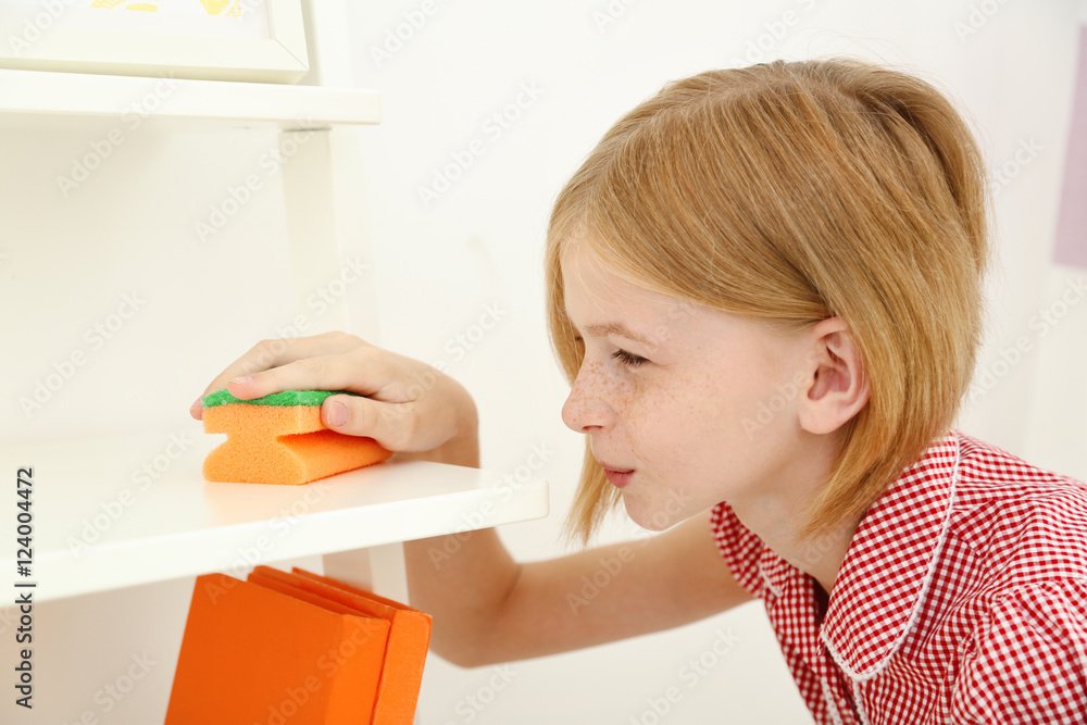 Small girl cleaning shelf with sponge, indoor Small girl cleaning shelf with sponge, indoor
