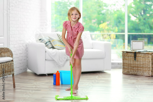 Small girl cleaning room wi...