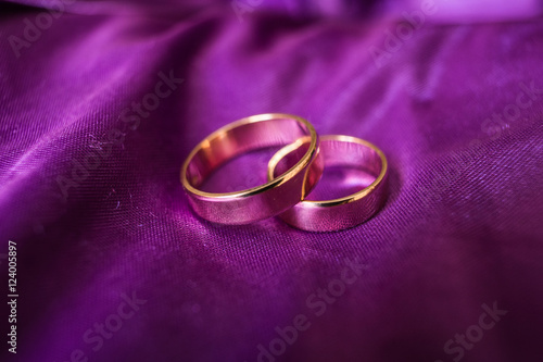 Wedding rings stand on the violet cloth