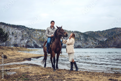 pregnant girl and her husband standing next to the horse © Artem