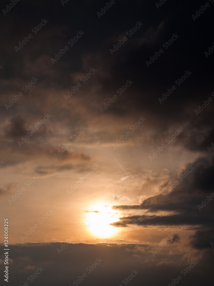 hazy sun behind cloud formations