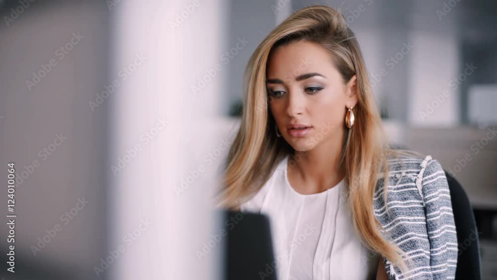 Happy businesswoman working on her laptop in the office Happy businesswoman working on her laptop in the office