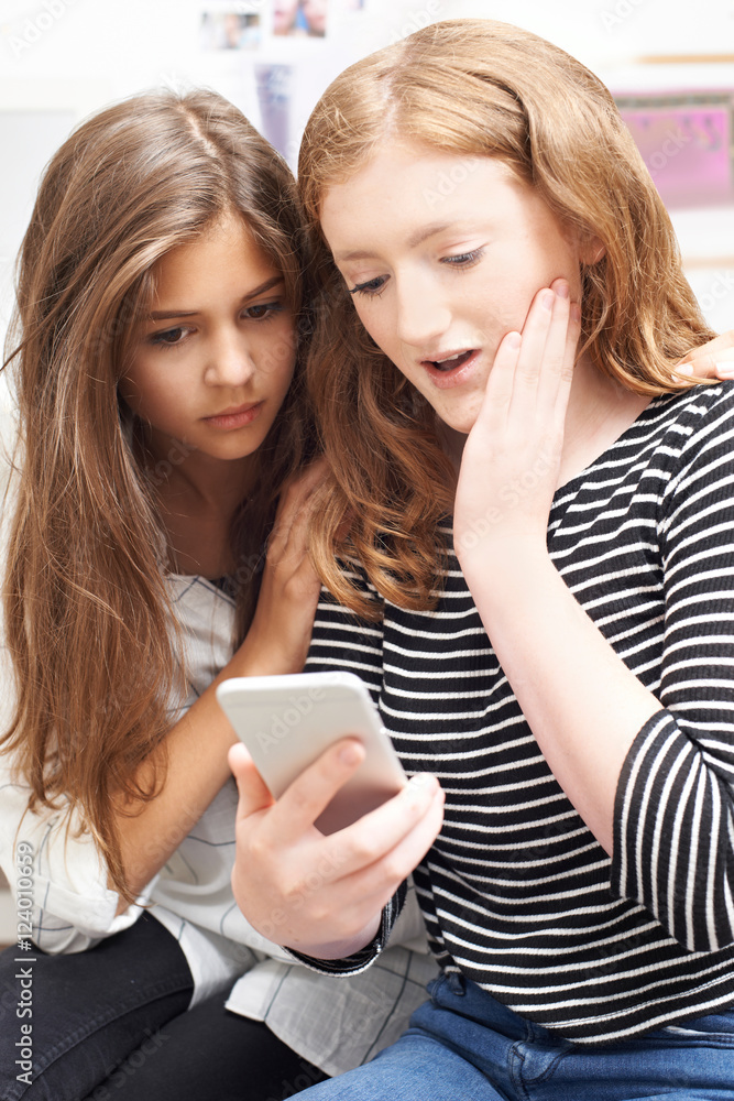 Teenage Girl With Friend Being Bullied By Text Message Teenage Girl With Friend Being Bullied By Text Message