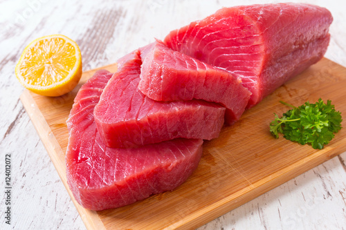 Raw tuna steak on wooden cutboard photo