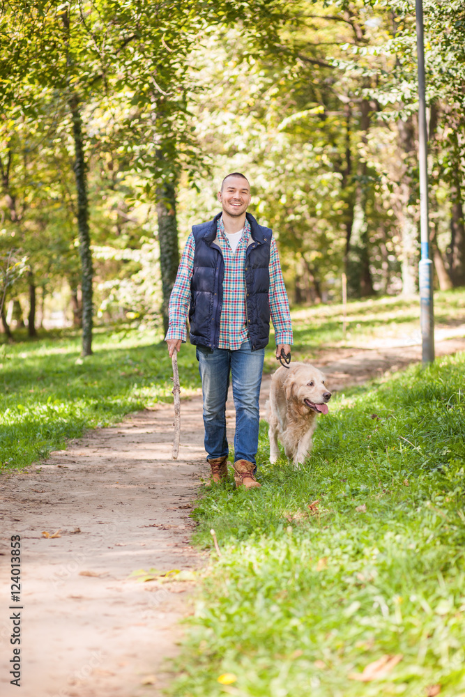 Young man walking a dog at the park in good weather. Boy and golden retriever.
Autumn environment Young man walking a dog at the park in good weather. Boy and golden retriever.
Autumn environment