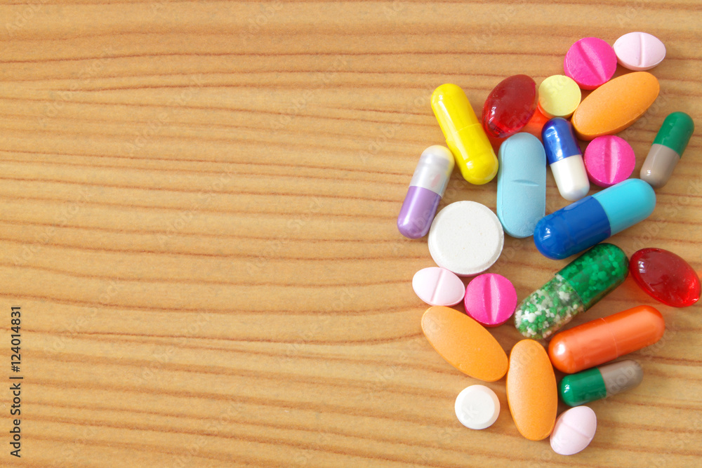 Colorful drugs on wooden table
