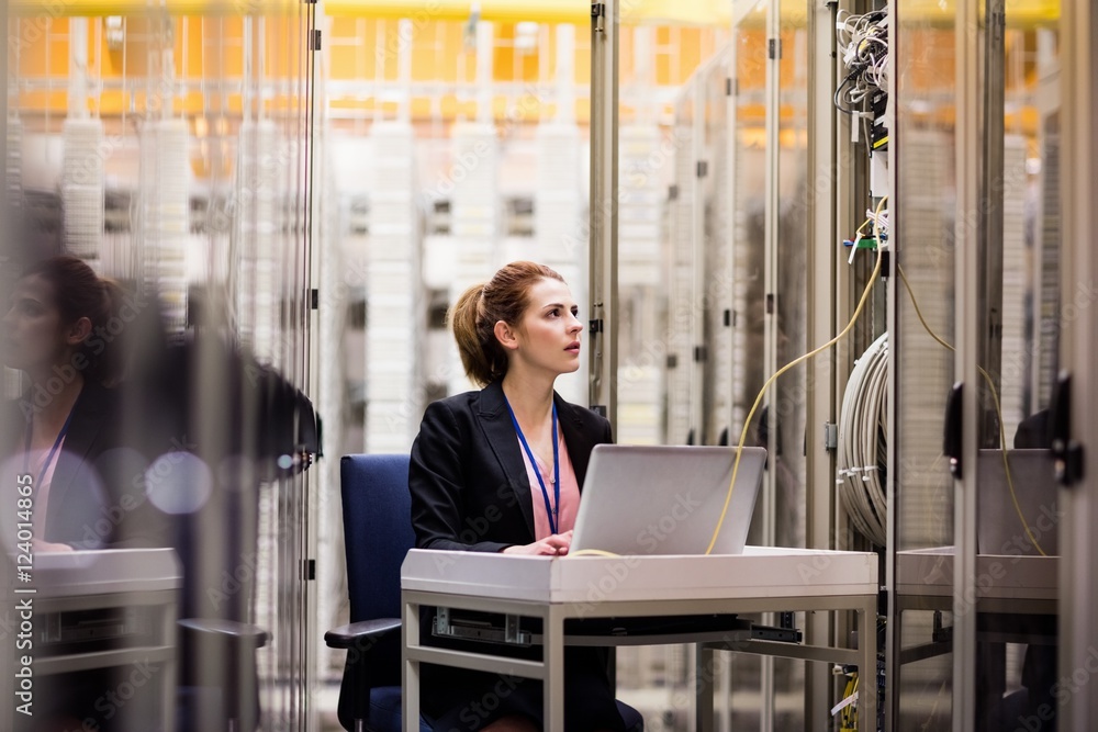 Fototapeta premium Technician using laptop while analyzing server