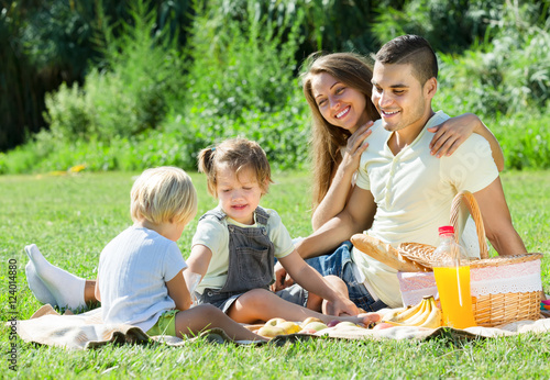Happy parents with children having picnic outdoor