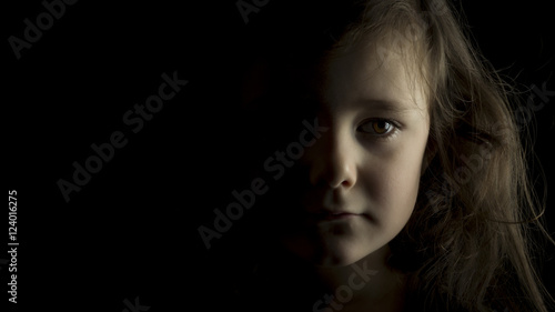 Portrait of a young girl on black background