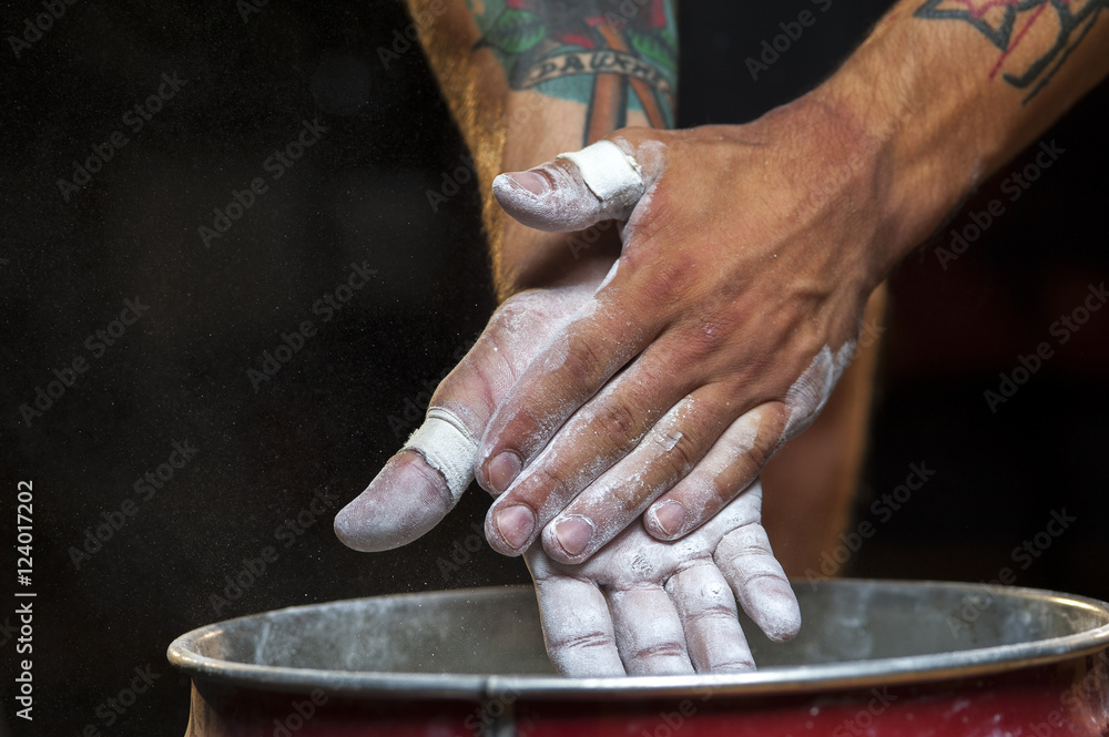 Hands of young man with chalk powder